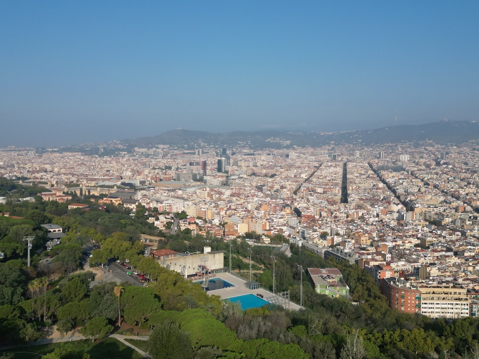 Aerial view of a dense cityscape with green areas.