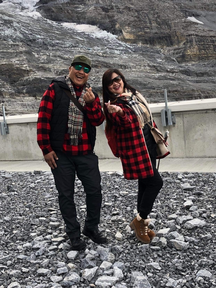 Couple posant dans des tenues assorties dans un lieu montagneux.