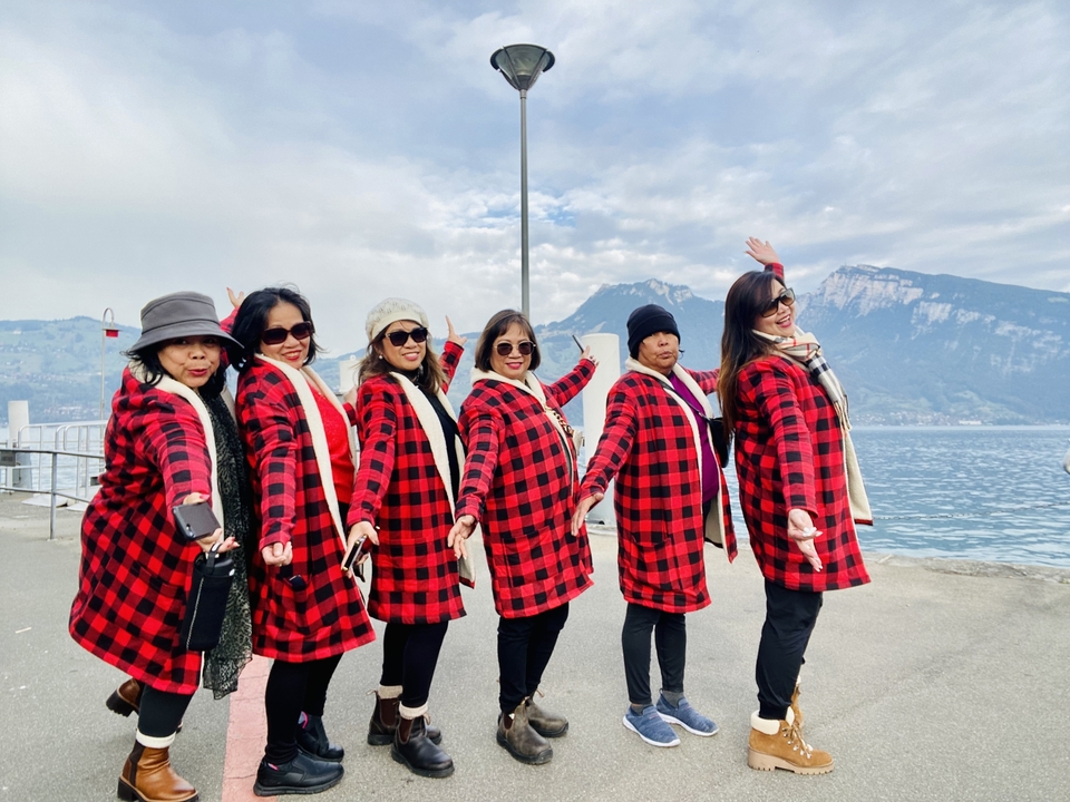 Femmes en tenues assorties posant près d'un lac avec des montagnes en arrière-plan.