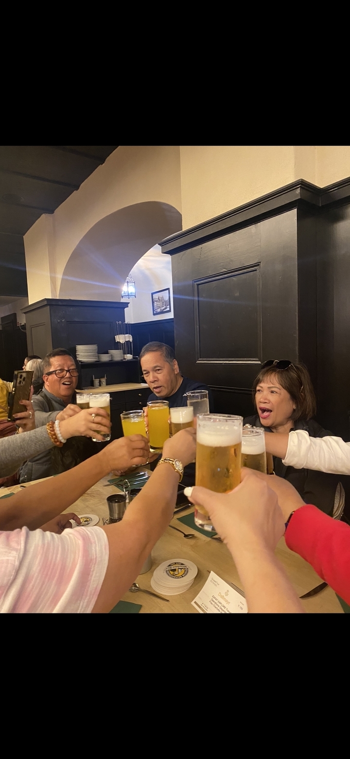 Groupe de personnes trinquant avec des chopes de bière dans un pub.