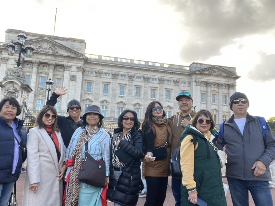 Groupe debout devant un bâtiment historique.