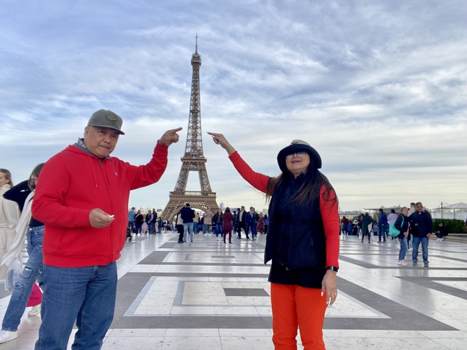 Couple posant avec la tour Eiffel en arrière-plan.