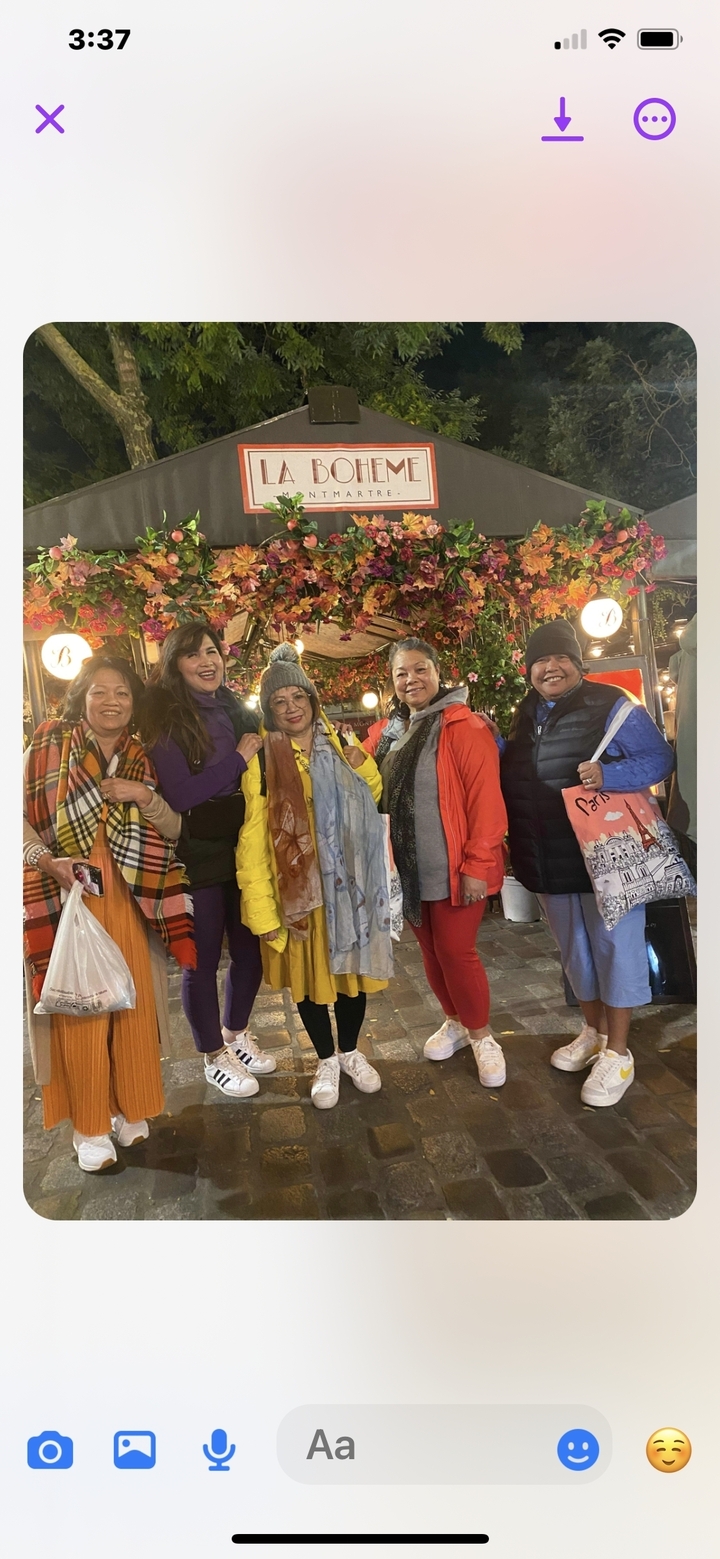 Groupe de femmes sous un dais fleuri dans un cadre urbain.