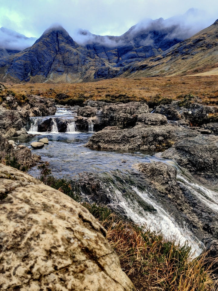 Flowing water over rocky terrain, creating small waterfalls.