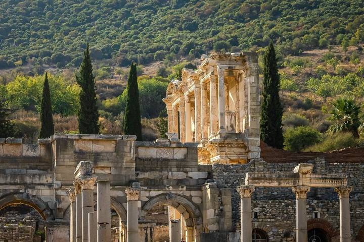 Ruines d'une ancienne structure de pierre entourée d'arbres.