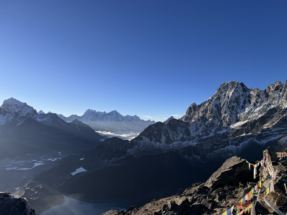 Expansive view of snow-covered mountains under a clear sky.