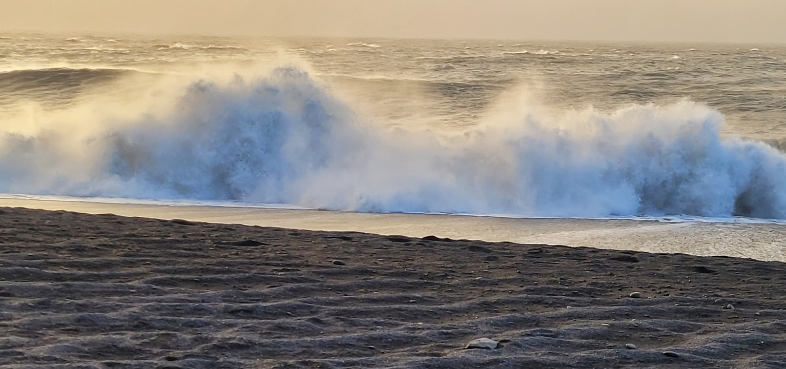 Olas rompiendo en una playa de arena.