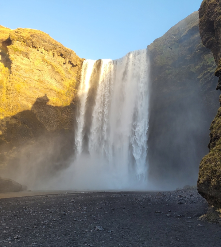 Gran cascada con neblina en la base, rodeada de acantilados.