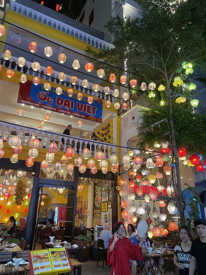 Une rue décorée de lanternes colorées la nuit.