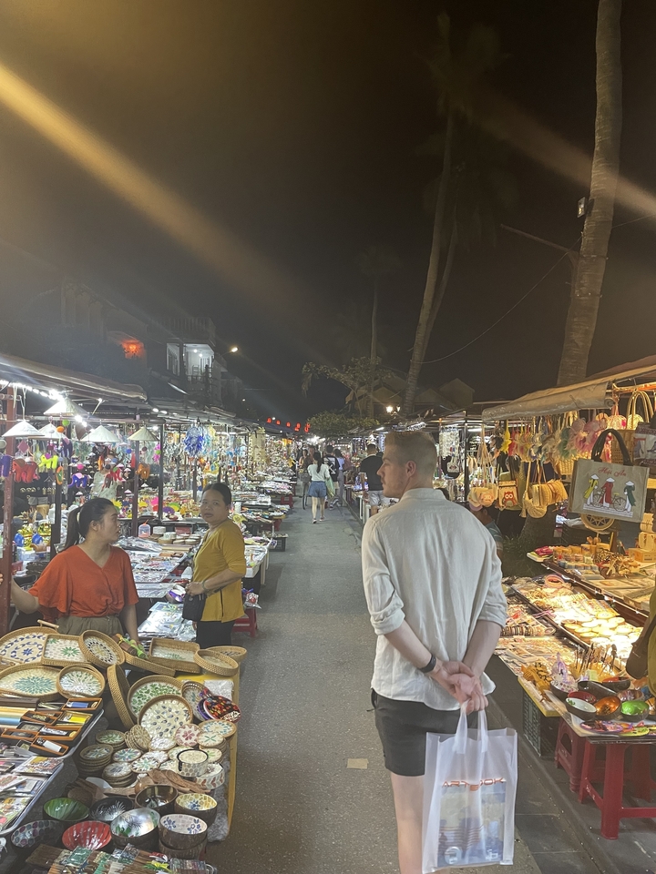 Des gens explorent un marché nocturne animé.