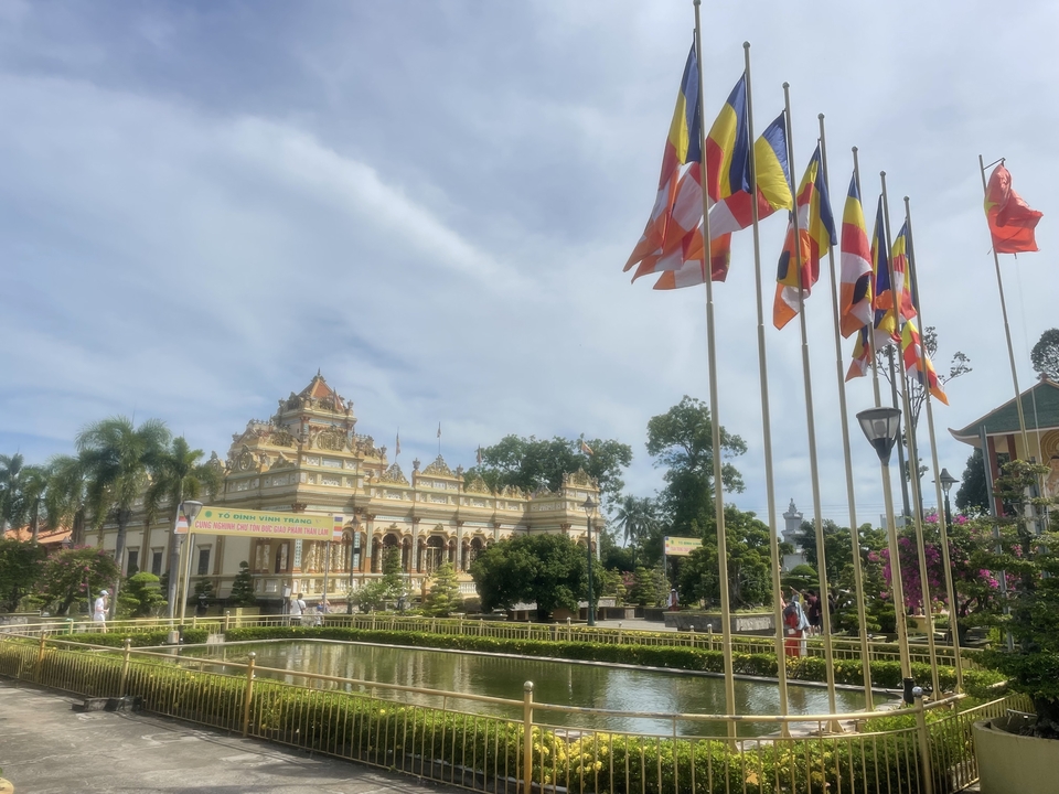 Un temple avec plusieurs drapeaux et un bassin de réflexion.