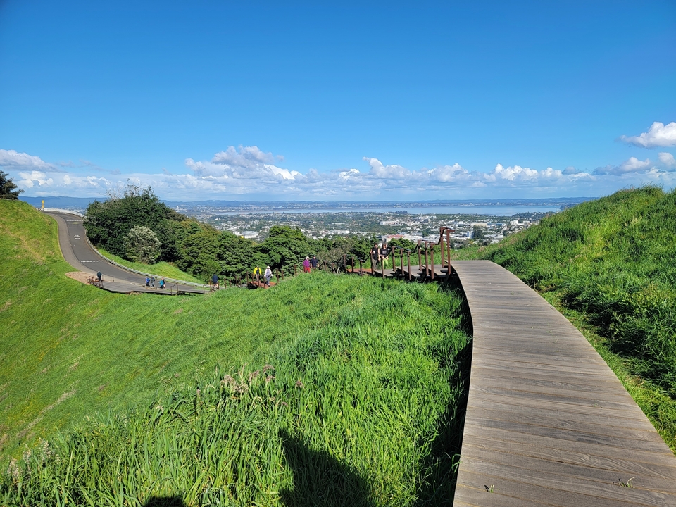 Vue panoramique d'une promenade dominant l'horizon urbain et l'eau.