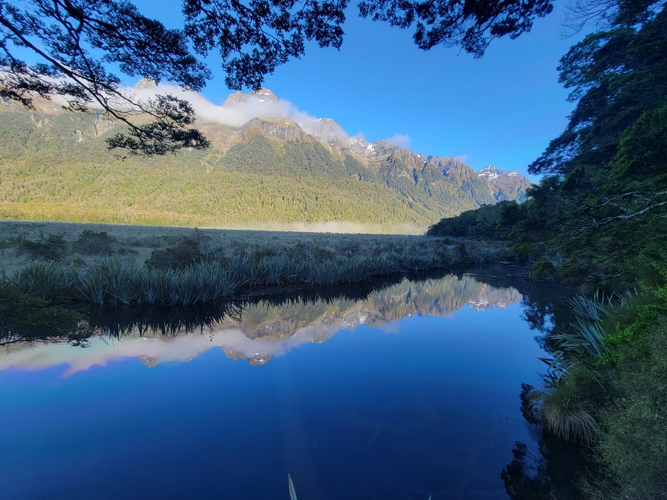 Une vue dégagée de montagnes se reflétant sur un lac calme.