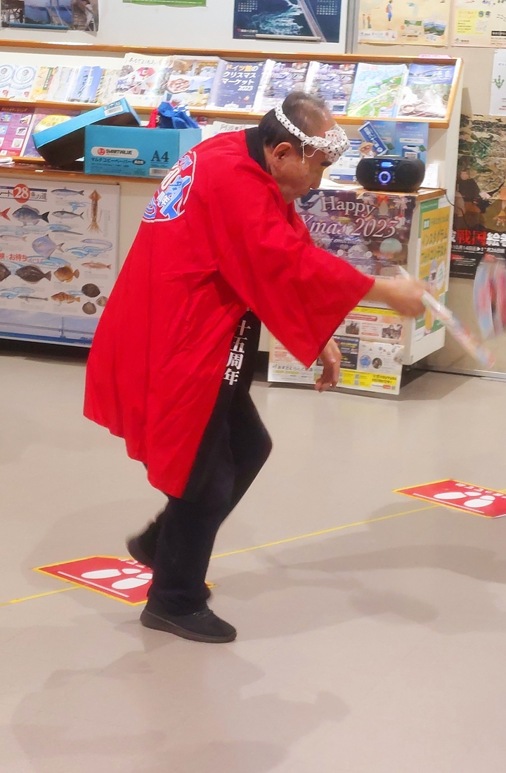 Person in red traditional attire performing an action indoors.