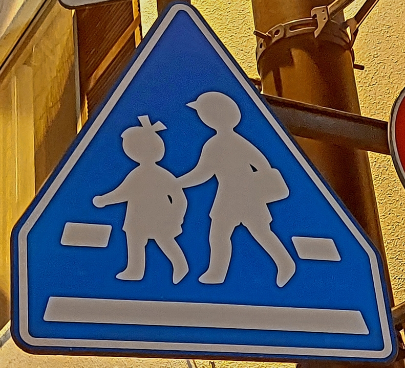 Blue and white pedestrian crossing sign.