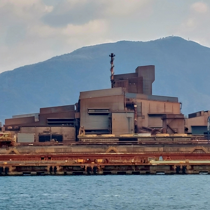 Industrial building with a mountain in the background.