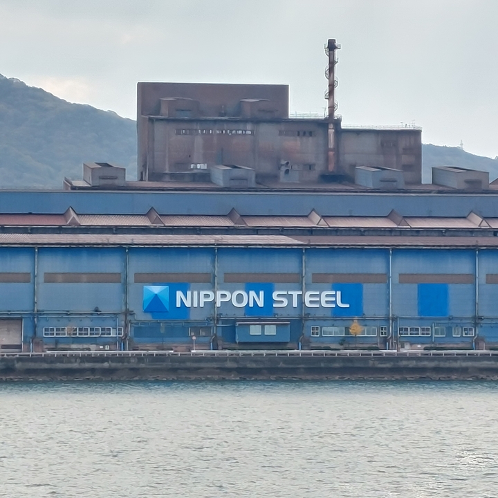 Large industrial building with Nippon Steel sign.