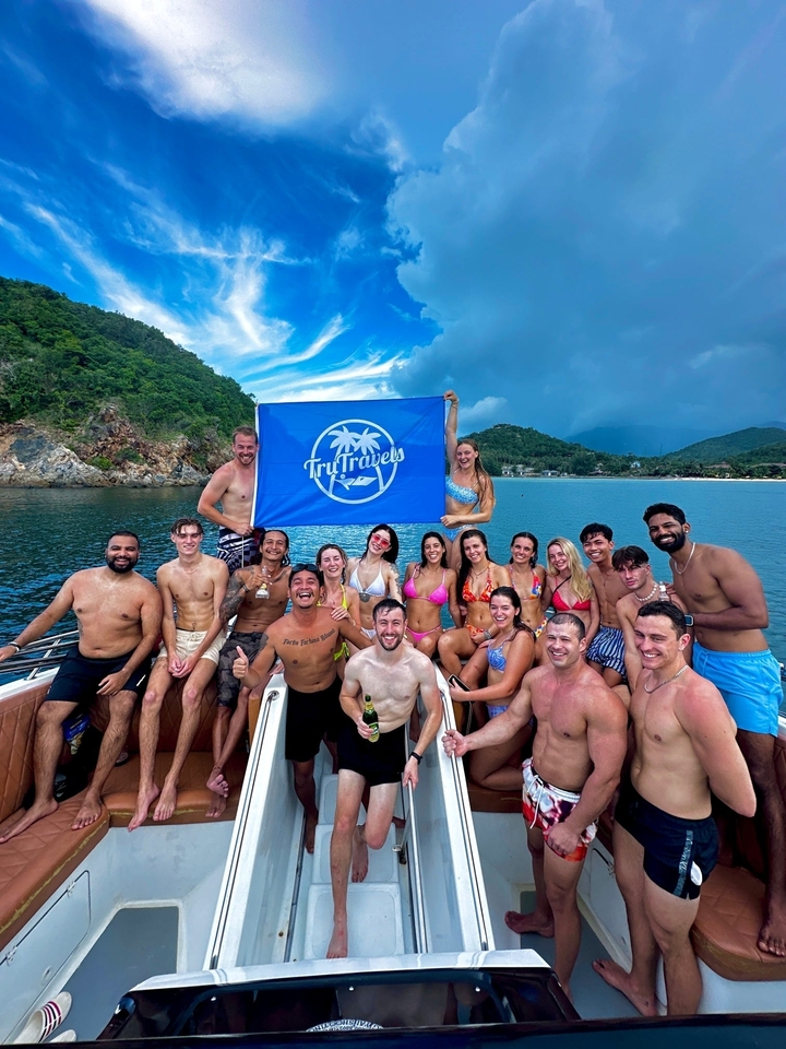 Group of people on a boat holding a flag.