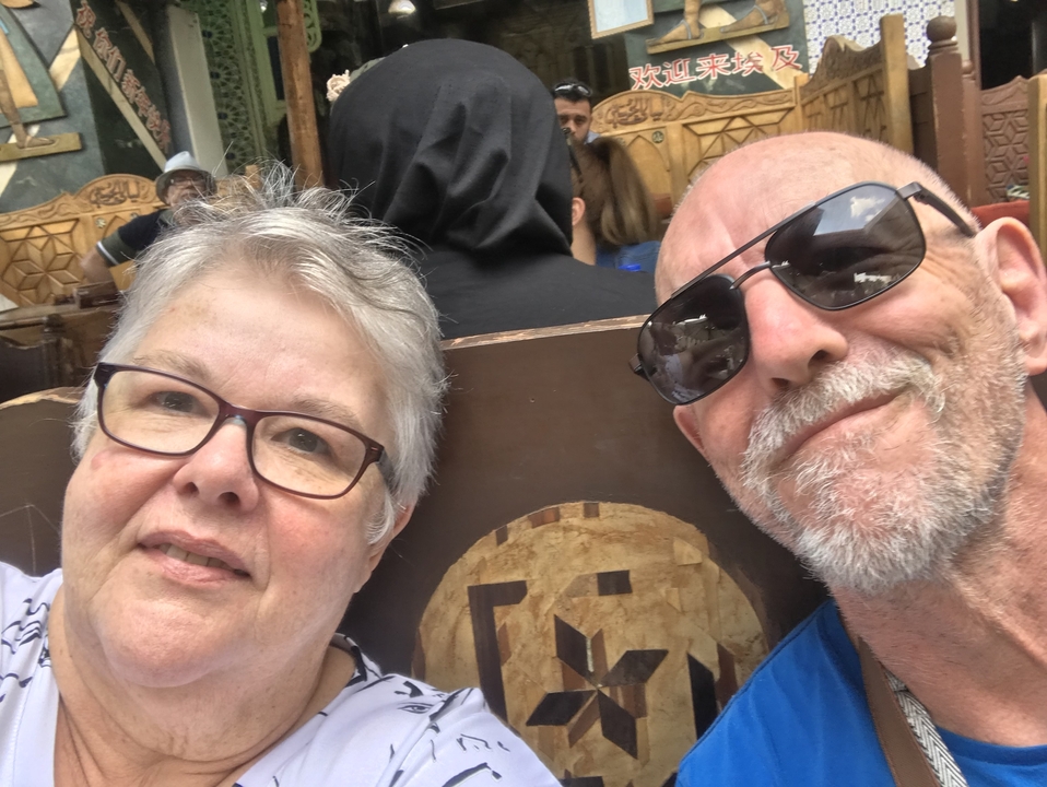 Gros plan de deux personnes souriantes dans un lieu bondé.