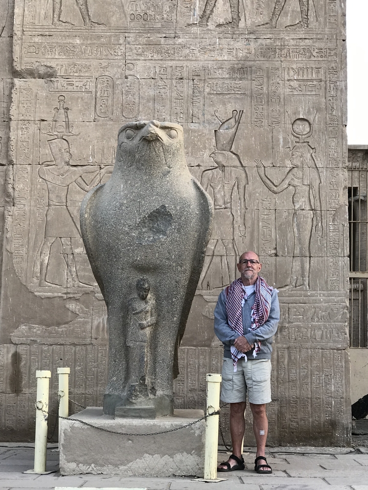 Personne posant avec une statue ancienne et des sculptures.