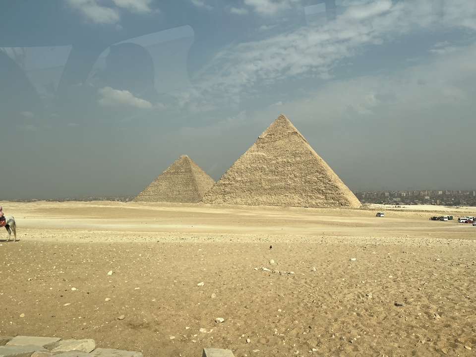 Deux pyramides dans le désert vues de loin.