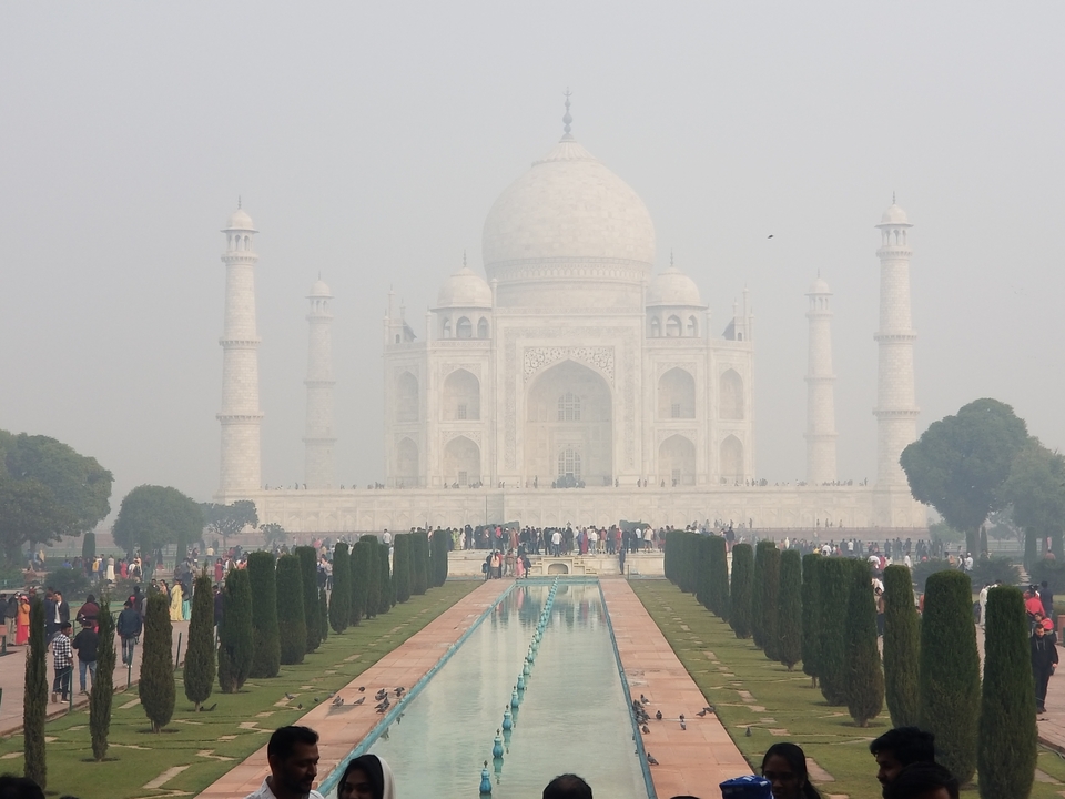 De Taj Mahal met mensen die op een mistige dag op bezoek komen.