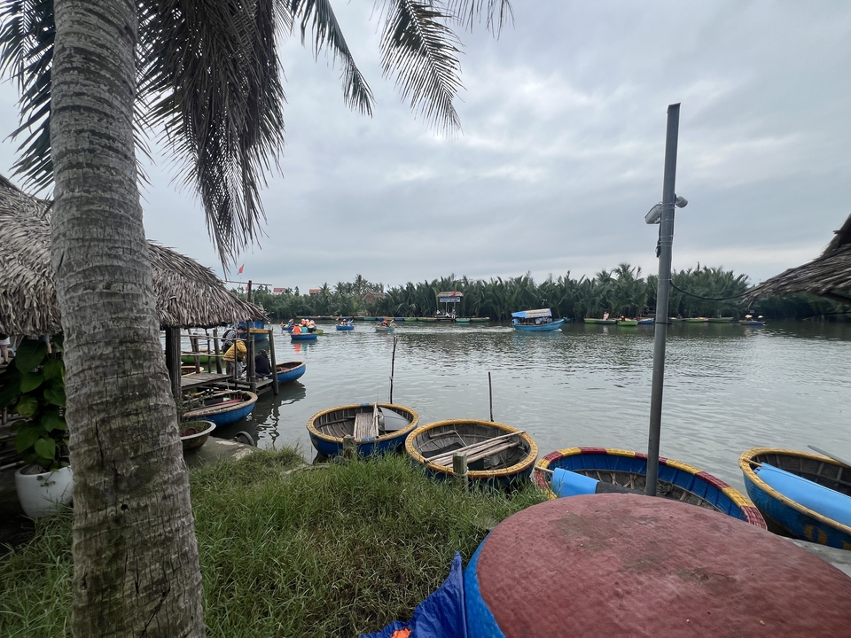 River with boats and palm trees, possibly in a rural setting.