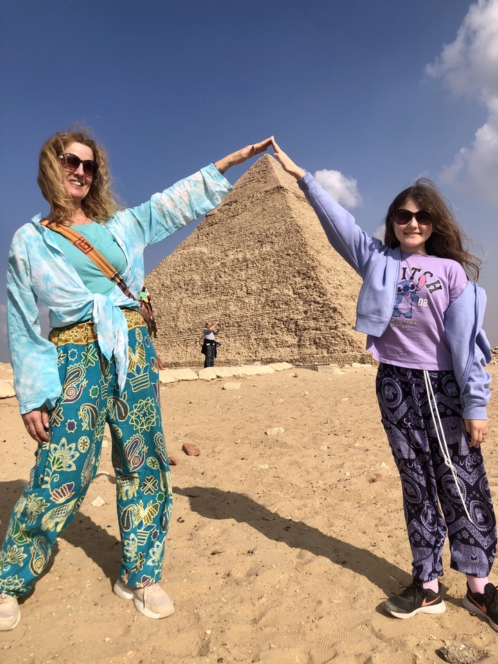 Two people mimicking holding a pyramid.

**Translation to French:**

Deux personnes imitant le fait de tenir une pyramide.