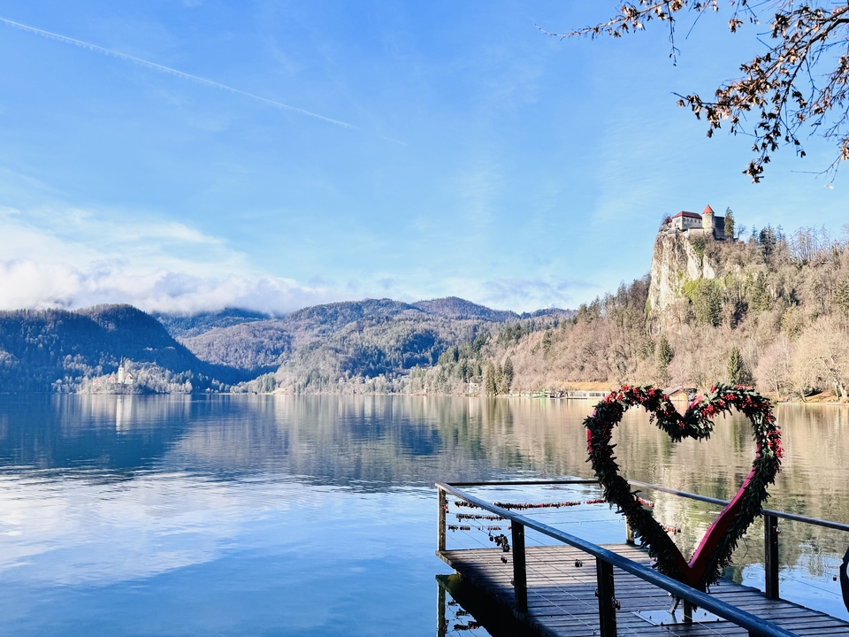A scenic lake view with mountains and a heart-shaped sculpture.
