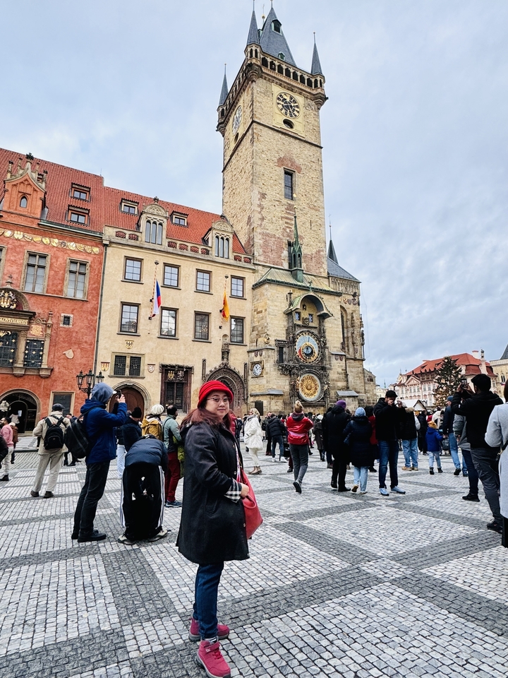 A historical clock tower in a bustling city square.