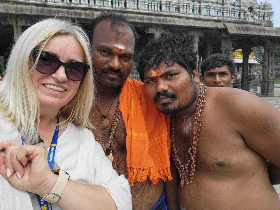 Touriste posant avec des hommes locaux vêtus traditionnellement.