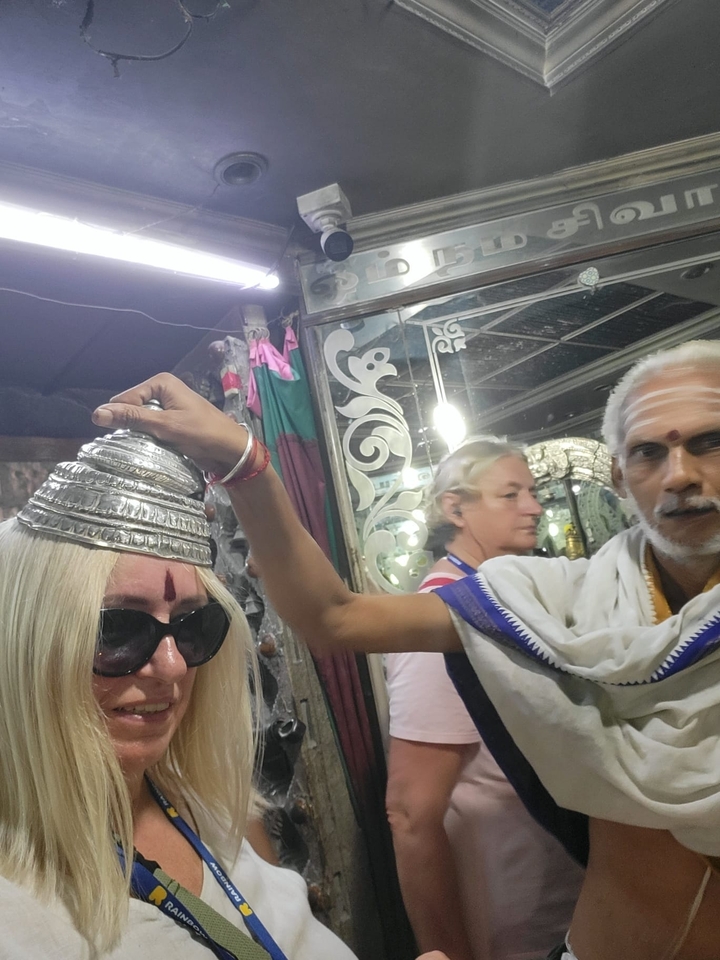 Personne bénie avec un pot d'argent dans une pièce décorée.