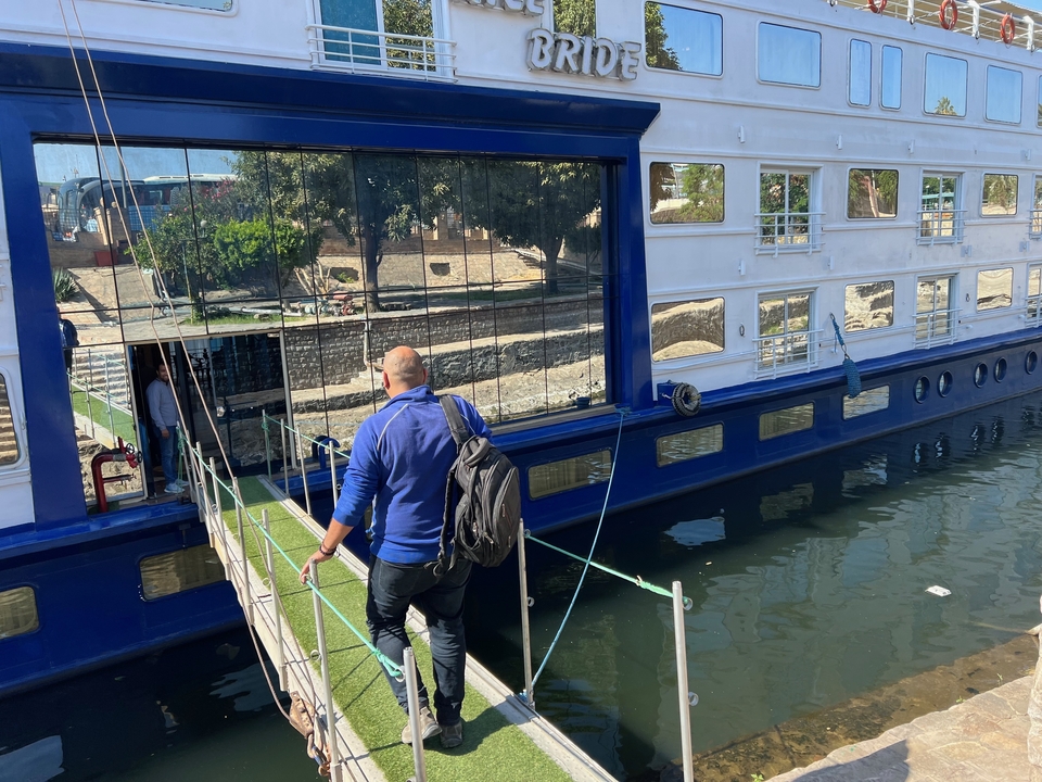 Homme embarquant sur un bateau de croisière fluviale par une journée ensoleillée.