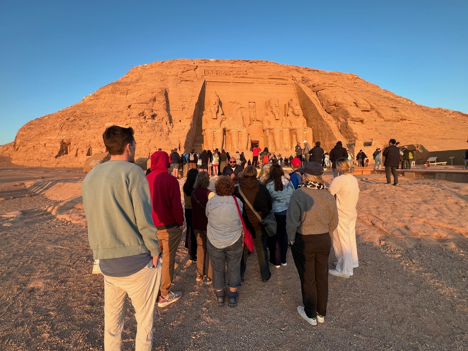 Des touristes se sont rassemblés à l'entrée d'Abou Simbel avec le soleil qui brillait.