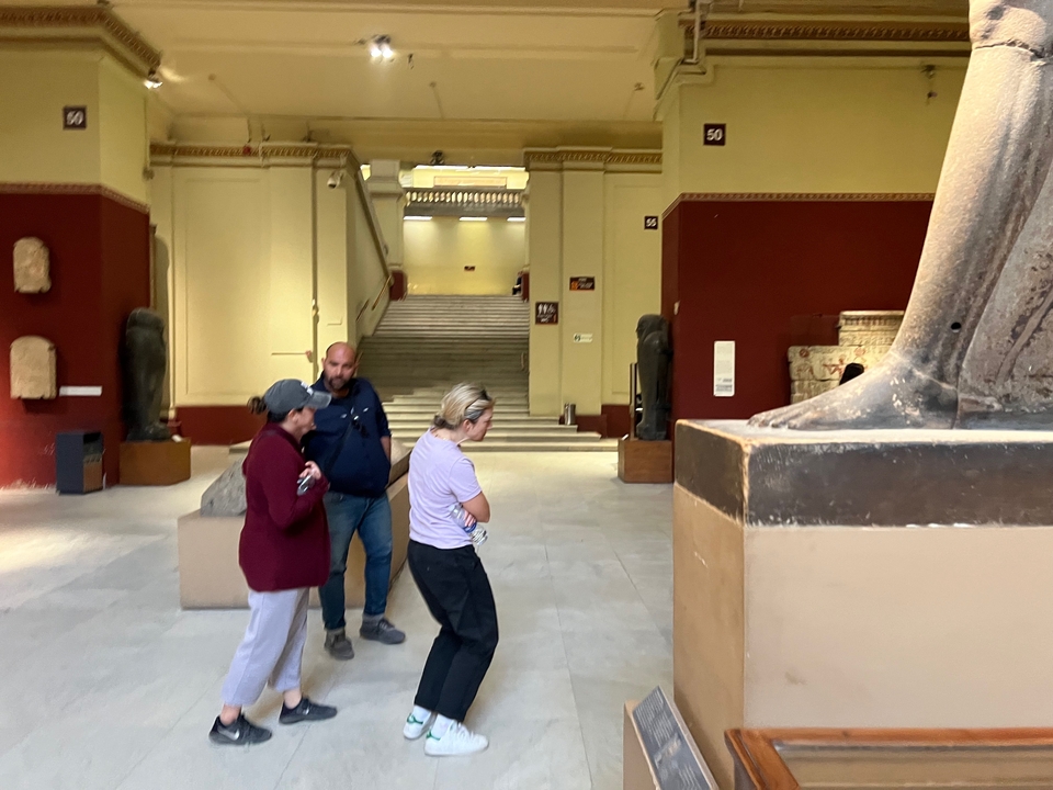 Des visiteurs observant des artefacts anciens à l'intérieur d'un musée.