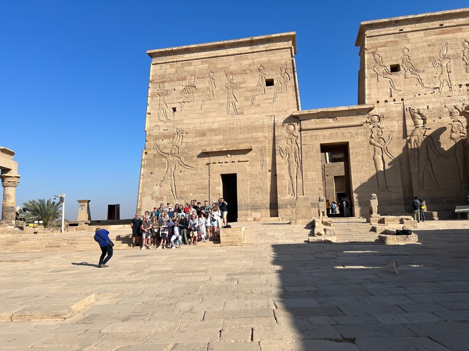 Tour group exploring ancient stone architecture with inscriptions.