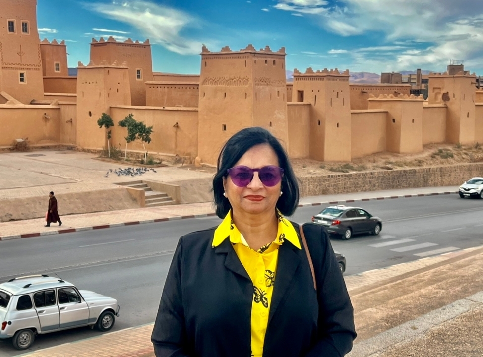Woman posing in front of a large historic walled structure