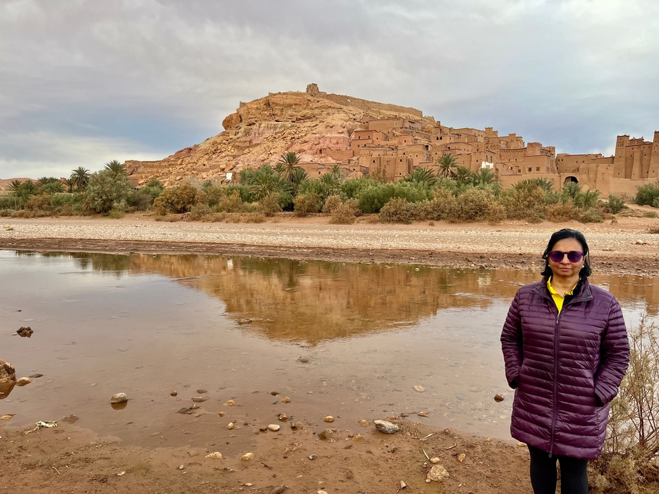 Woman near a river with a historic fortress in the background