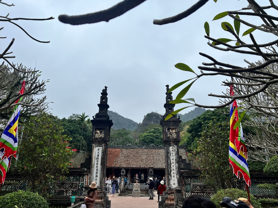 Entrée de temple avec drapeaux et feuillage.