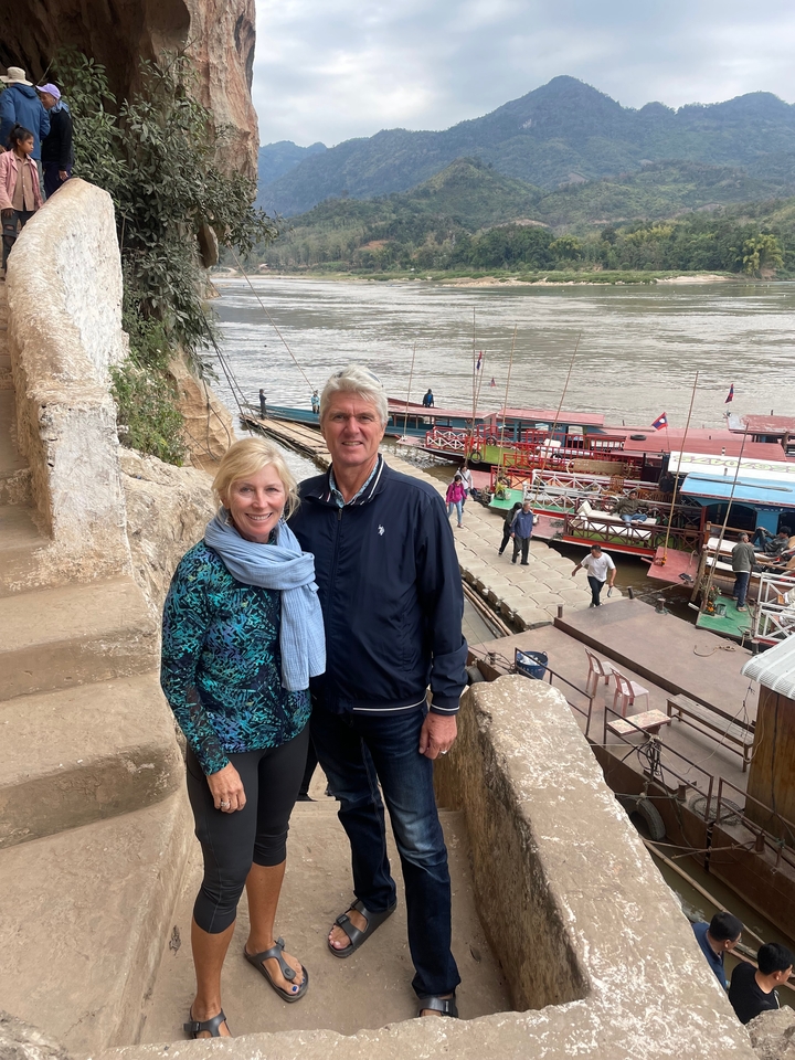 Couple au bord d'une rivière avec des bateaux.