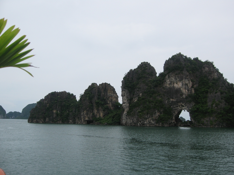 Rock formations with holes rising from the sea.