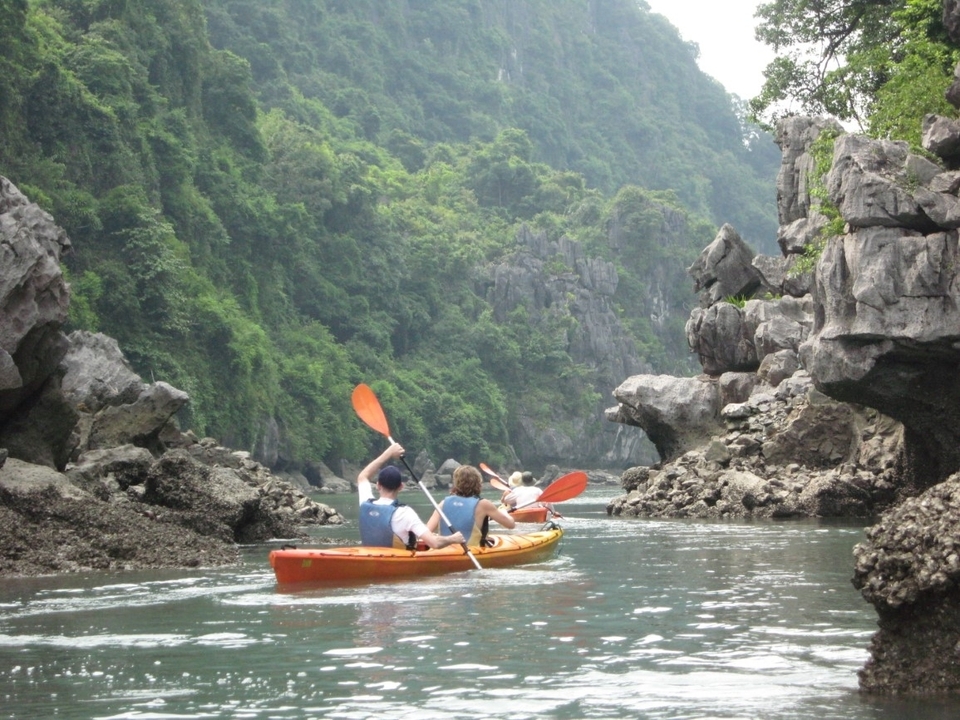 Des personnes faisant du kayak à travers un passage rocheux étroit.