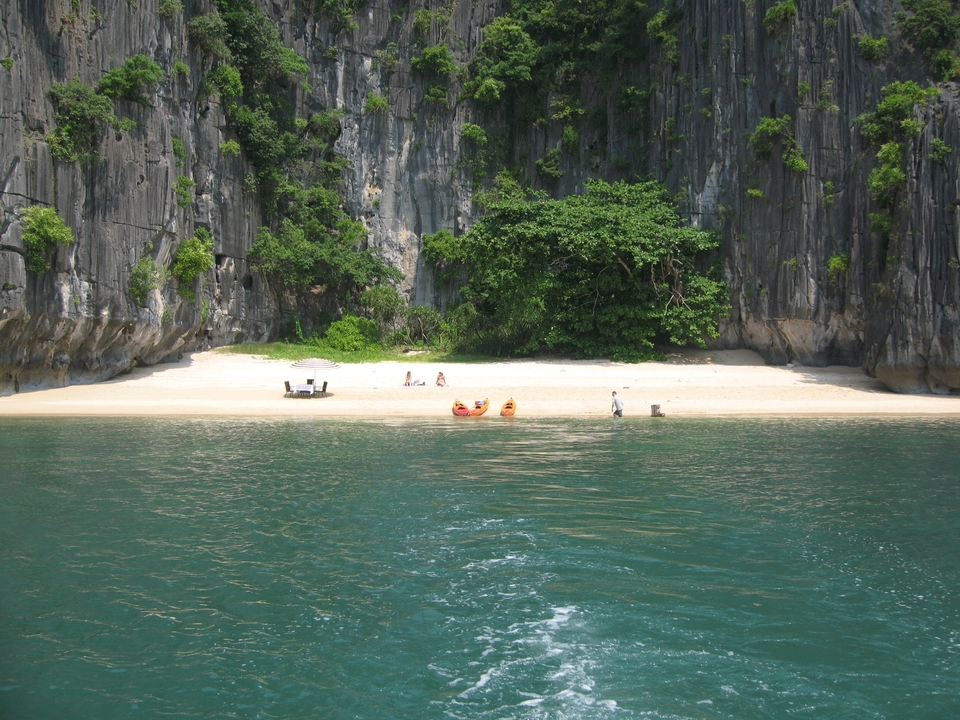 Sandy beach with two kayaks and people