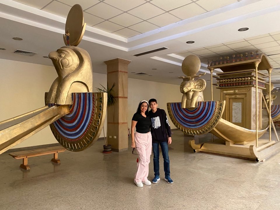 Deux personnes debout dans un musée avec des répliques de bateaux égyptiens.