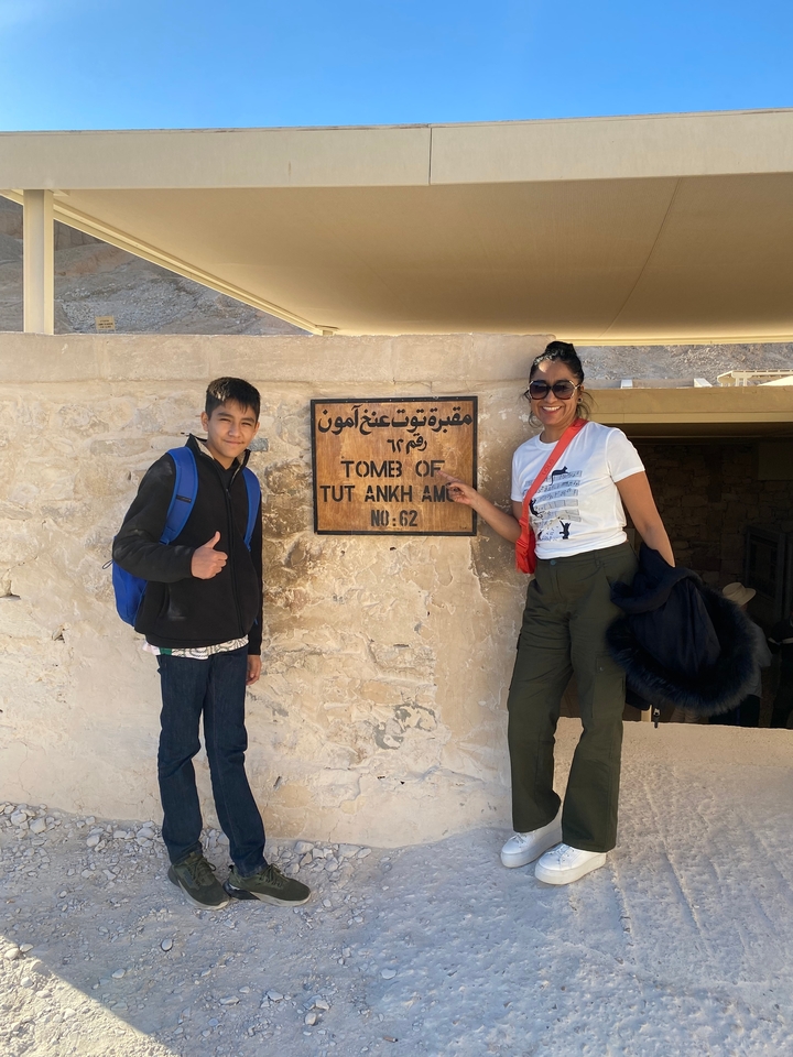 Deux personnes pointant du doigt un panneau pour la tombe de Toutânkhamon.