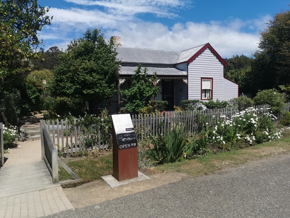 Historic cottage with garden and picket fence.