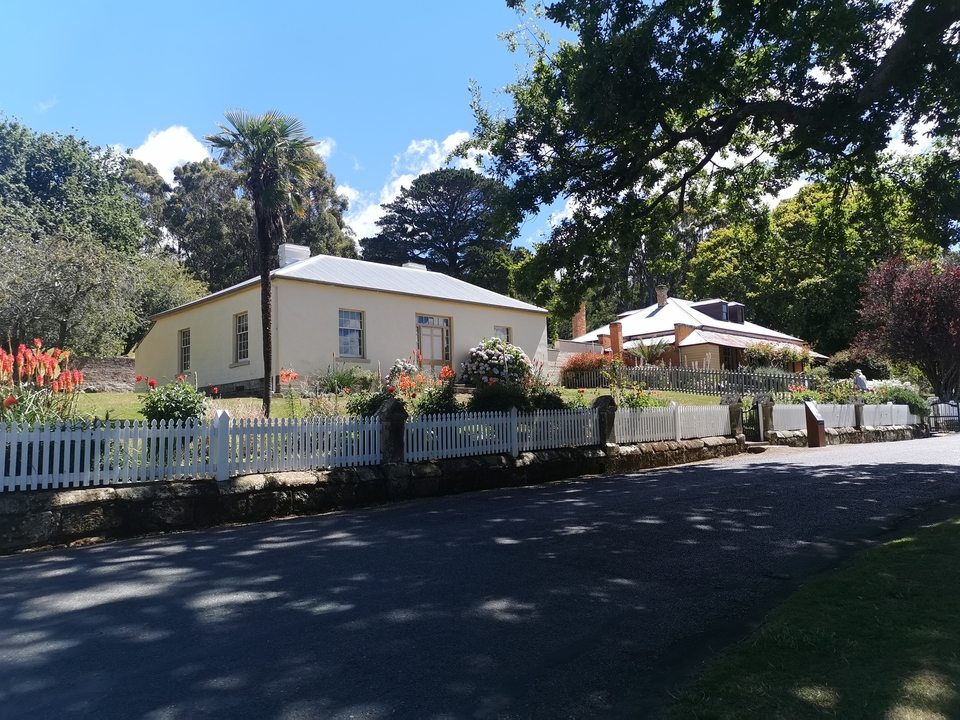 House with colorful garden and picket fence.