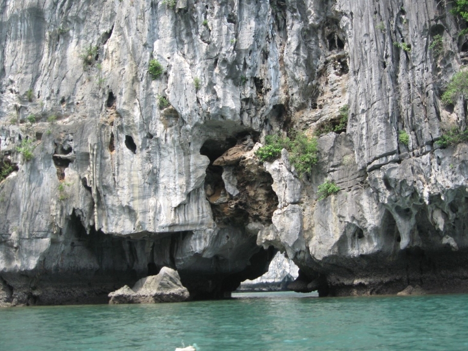 Falaises calcaires avec une arche naturelle et les eaux environnantes.