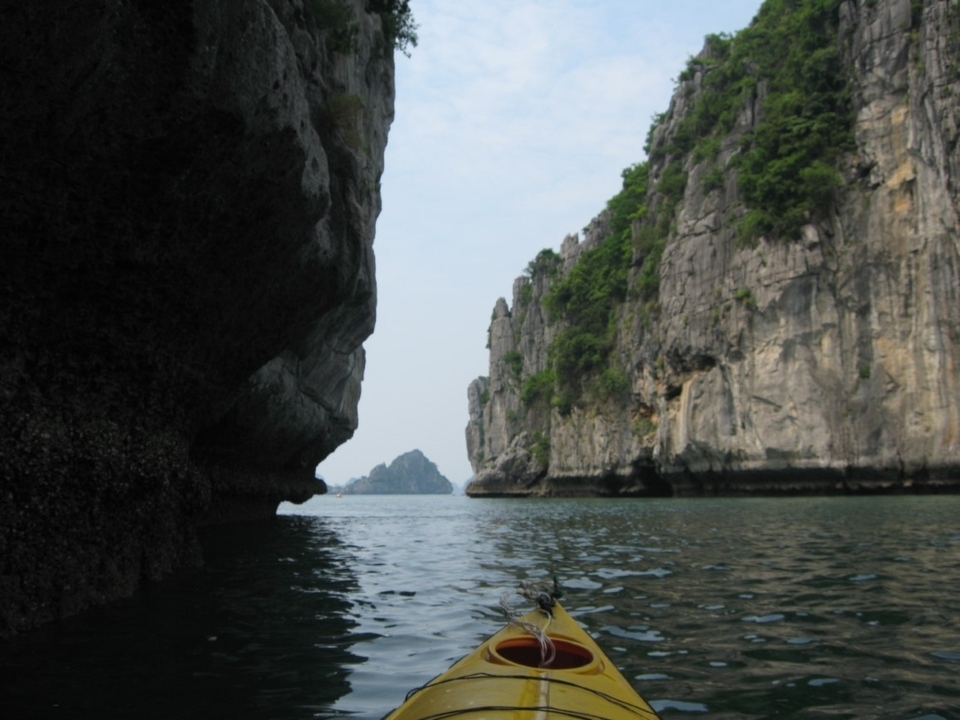 Falaises rocheuses et cours d'eau sous un ciel nuageux.