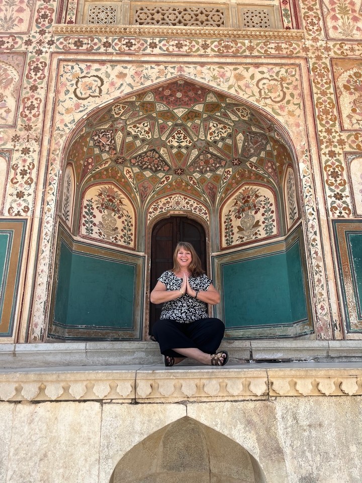 Femme posant devant une porte richement décorée.